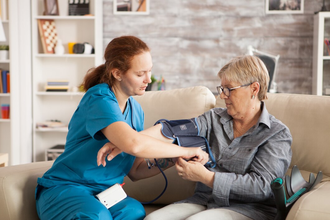 Nurse checking an older patient’s blood pressure in a care setting