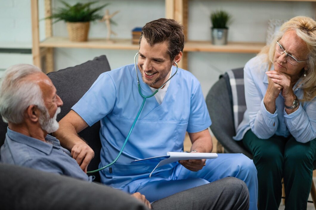 Doctor listening to an older patient’s heartbeat during a home visit